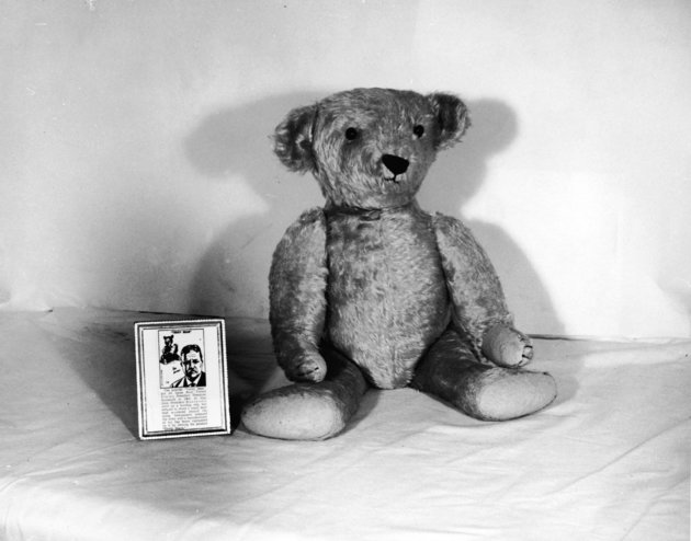A teddy bear in the 1950s sits next to its tag explaining its link to President Theodore Roosevelt. 